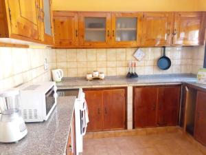 a kitchen with wooden cabinets and a white microwave at Larry's Place in Kampala