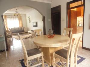 a dining room with a wooden table and chairs at Larry's Place in Kampala