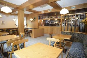 a restaurant with wooden tables and chairs and a bar at Hotel Canada in Andalo