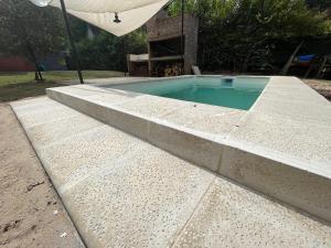 a small swimming pool with a concrete curb at NATURALMENTE in Santa Ana