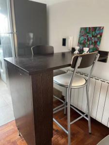 escritorio de madera con 2 sillas y mesa en Moderno Departamento, en la mejor zona de Mendoza en Mendoza