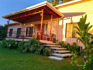 une maison avec des escaliers menant à une terrasse couverte dans l'établissement Monteverde House, à Monteverde Costa Rica