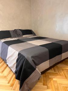 Cama grande en habitación con suelo de madera en Monoambiente Moderno 2 cuadras Plaza de Mayo en Buenos Aires