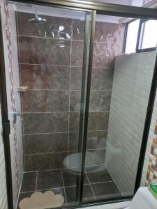 y baño con ducha y puerta de cristal. en APARTA-HOTEL BADEN, en Bogotá