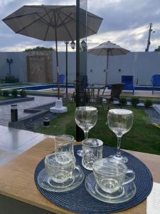 a tray with glasses and plates on a table at Villa Suíça Ibiapaba in Tianguá