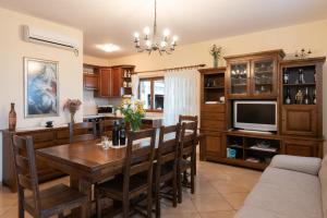 a kitchen with a dining room table and a tv at Holiday Villa Natura in Orebić