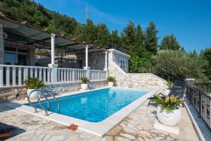 a swimming pool in a backyard with a house at Holiday Villa Natura in Orebić