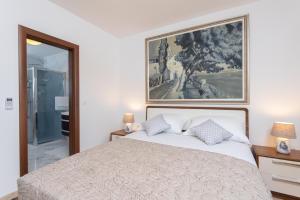 a bedroom with a bed and a painting on the wall at Holiday Villa Natura in Orebić