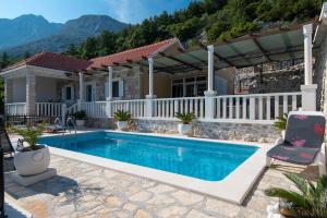 a swimming pool in front of a house at Holiday Villa Natura in Orebić