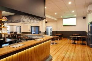 a bar in a restaurant with tables and chairs at Sports Garden Hotel in Launceston
