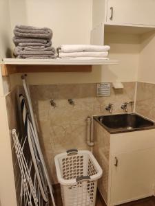 a bathroom with a sink and towels on a shelf at Home Away From Home in Richmond