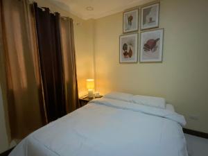a bedroom with a white bed and a window at Divine Resort Corporation in Moalboal