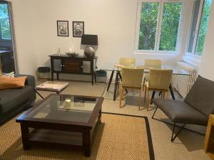 sala de estar con sofá, mesa y sillas en Appartement paisible proche centre ville, en Villennes-sur-Seine
