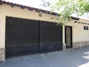 a pair of garage doors on a house at Quinta Montaña - Casa entera grupo o familia 8-10 personas - céntrica, piscina - Todas las comodidades! in Mendoza