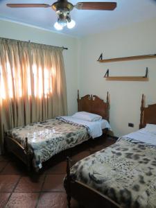 a bedroom with two beds and a ceiling fan at Quinta Montaña - Casa entera grupo o familia 8-10 personas - céntrica, piscina - Todas las comodidades! in Mendoza