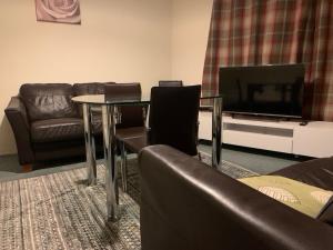 a living room with a couch and a table and a tv at One Bedroom Apartment Near QMC & University of Nottingham in Nottingham