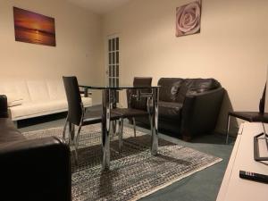 a living room with a glass table and a couch at One Bedroom Apartment Near QMC & University of Nottingham in Nottingham