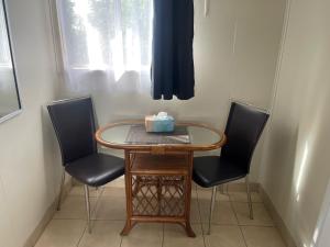 a small table with two chairs and a box on top at Avocado Motor Inn in Childers