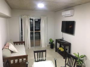 een woonkamer met een bank en een flatscreen-tv bij BELGRANO SUITES in Salta