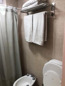 a bathroom with a toilet and a sink and towels at 11 De Septiembre 3255 in Mar del Plata