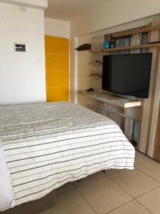 1 dormitorio con 1 cama y TV de pantalla plana en 11 De Septiembre 3255 en Mar del Plata