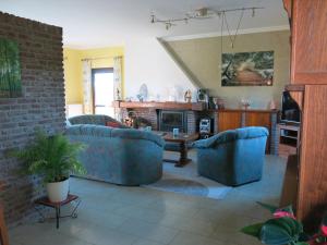 a living room with two blue couches and a fireplace at Carpe Diem in Bullange