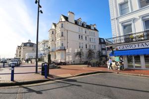 a city street with buildings and a street sign on a pole at New Sunset Square Eastbourne 2 Bed Apartment, Long stay welcome in Eastbourne