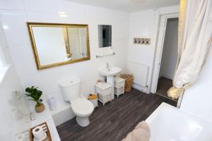 a white bathroom with a toilet and a sink at New Sunset Square Eastbourne 2 Bed Apartment, Long stay welcome in Eastbourne