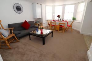 uma sala de estar com um sofá e uma mesa em New Sunset Square Eastbourne 2 Bed Apartment, Long stay welcome em Eastbourne