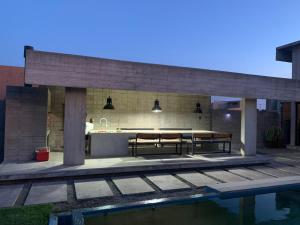 patio con mesa, cocina y piscina en bunker en San Pedro