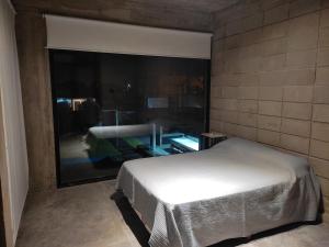 a bedroom with a bed and a large window at bunker in San Pedro +13 photos
