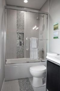 a bathroom with a toilet and a shower and a sink at ViewPoint Suites in Los Angeles