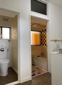 a bathroom with a toilet and a bath tub at 江ノ島に近い富士山も眺めるまるまる貸切一軒家ーーー湘南の丘のヴィラ in Fujisawa