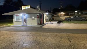 eine Tankstelle in der Nacht mit einem LKW draußen in der Unterkunft American Inn Motel in Many