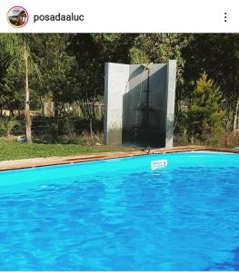 a blue swimming pool with a monument in the background at HABITACIONES ALUC, se reserva solo con seña in Chuy