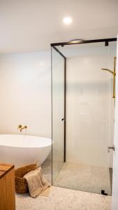 y baño con bañera y puerta de ducha acristalada. en Amazing view Architech Home 8Minutes to Hobart CBD, en Hobart