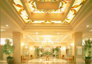 a hotel lobby with a ceiling with a chandelier at Hotel Listel Inawashiro Wing Tower in Inawashiro