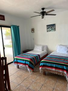1 Schlafzimmer mit 2 Betten und einem Deckenventilator in der Unterkunft CASA PARAÍSO in Xcalak