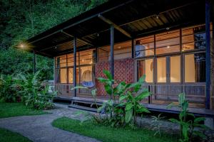 Kuyana Amazon Lodge في Archidona: منزل خشبي مع الكثير من النوافذ