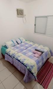 ein kleines Bett in einem Zimmer mit Fenster in der Unterkunft Apartamento inteiro próximo à Miguel Sutil in Cuiabá