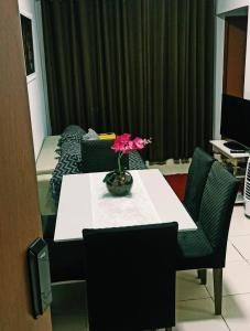una habitación con una mesa con un jarrón con una flor. en Apartamento inteiro próximo à Miguel Sutil, en Cuiabá