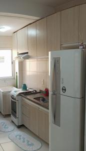 Apartamento inteiro próximo à Miguel Sutil في كويابا: مطبخ مع ثلاجة بيضاء وموقد