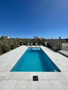 - une piscine avec 2 chaises dans l'établissement Las Piedritas Casa de Mar Loft, à Las Grutas