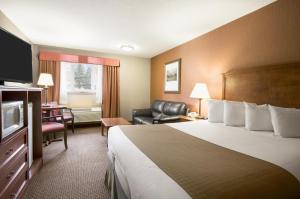 a hotel room with a large bed and a desk at Canmore Inn & Suites in Canmore +41 photos