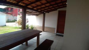 a patio with a wooden bench and a table at Casa Praia 1000 - Guriri Norte in São Mateus