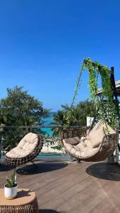 長灘島的住宿－The Paragon Boracay Suites，两把藤椅坐在海滩附近的庭院