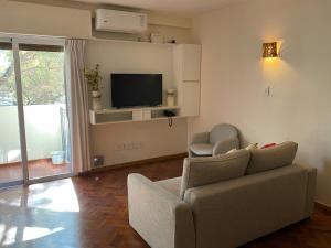 sala de estar con sofá y TV en Cómodo departamento en el centro de Mendoza en Mendoza