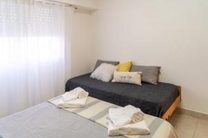 1 dormitorio con 2 camas y toallas. en Moana Alojamientos en Junín
