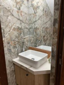 baño con lavabo y pared de piedra en Apartamento a 10 min del centro de la ciudad, en Huaraz