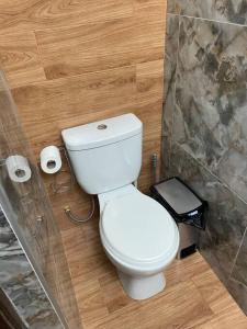 a bathroom with a toilet and two rolls of toilet paper at Apartamento a 10 min del centro de la ciudad in Huaraz